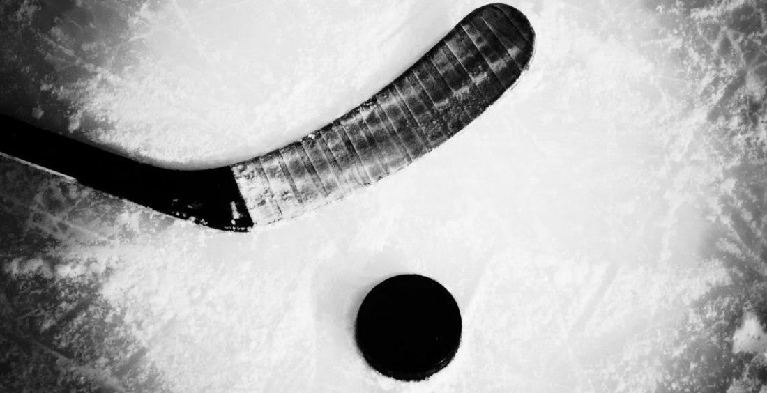 branded ice hockey sticks and puck black and white